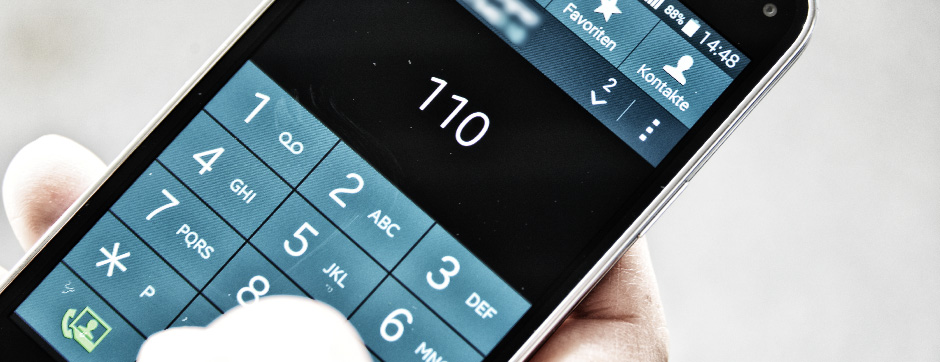 Es ist ein Smartphonedisplay in Nahaufnahme zu sehen, die "110" ist eingetippt.